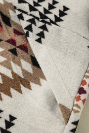 Southwestern quilted jacket in eggshell with geometric patterns in brown, black, and burgundy.