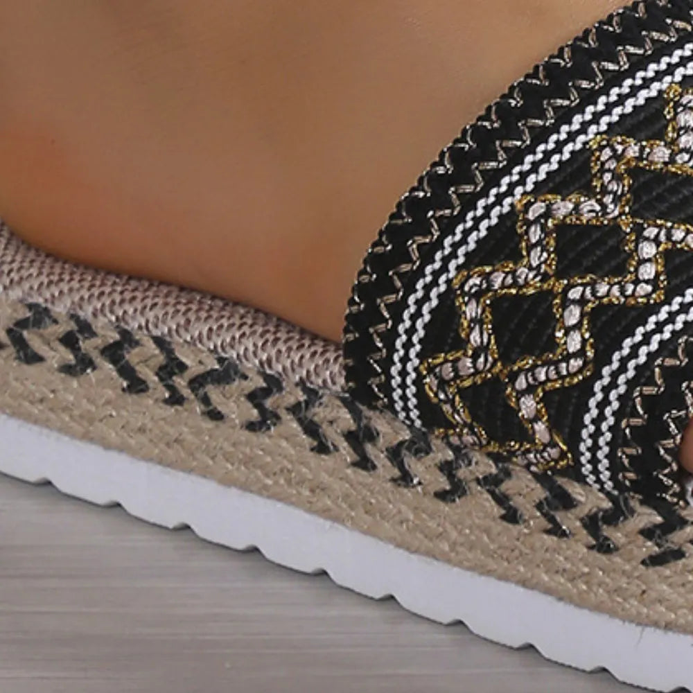 Embroidered espadrille platform slides in black with gold and white geometric pattern.