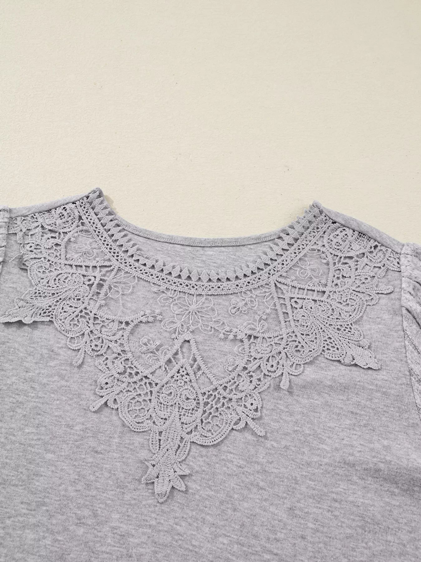 Gray ribbed knit long-sleeve top with intricate lace neckline detail