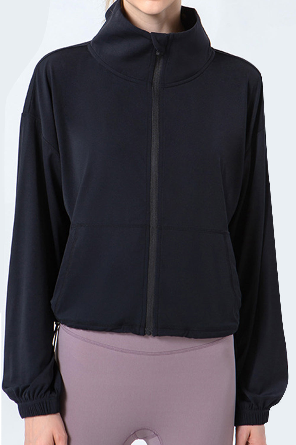 Black active jacket with gathered hemline, mock neck, and zippered front.