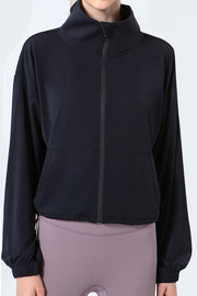 Black active jacket with gathered hemline, mock neck, and zippered front.