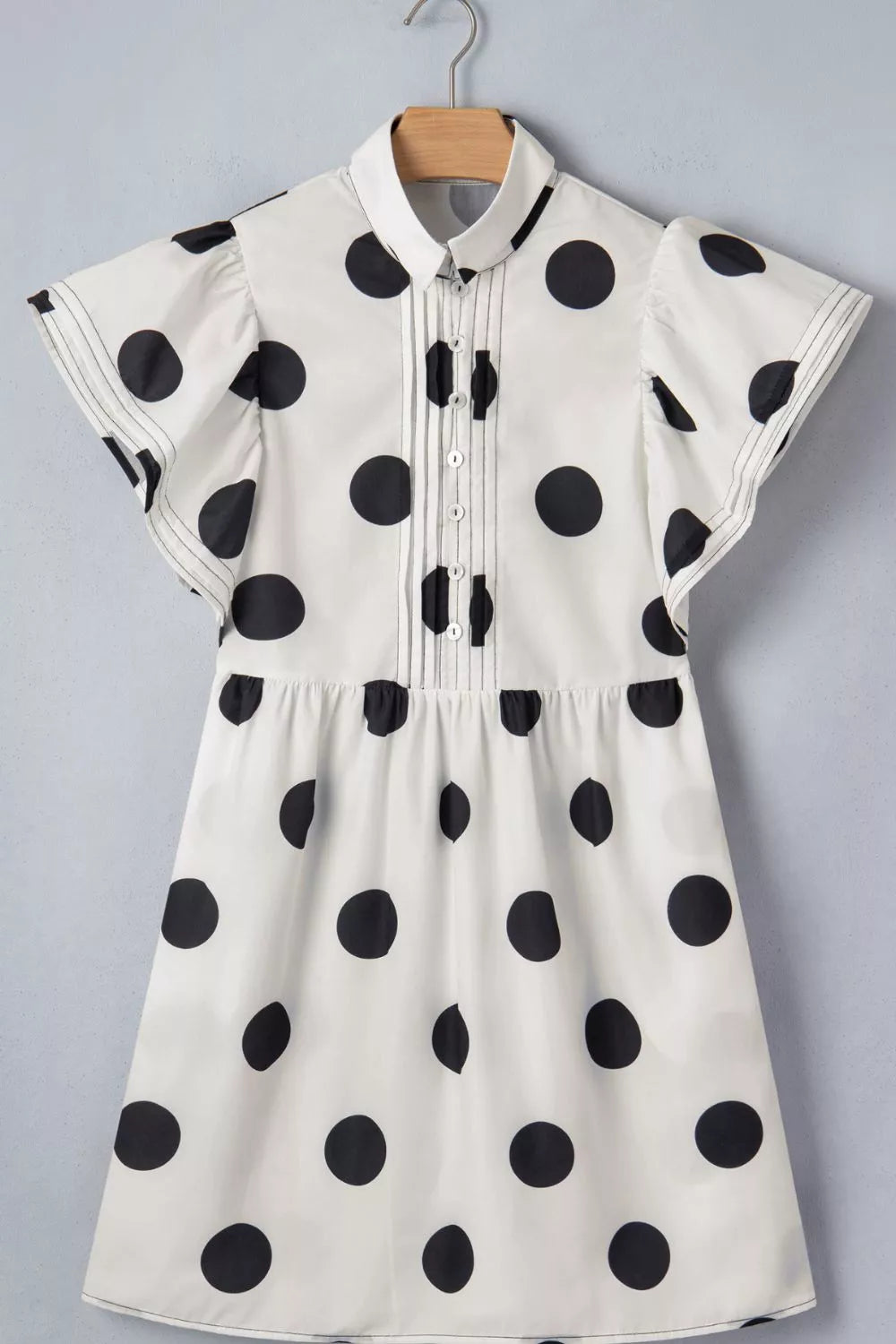 White polka dot mini dress with ruffled sleeves, collared neckline and button-down front.
