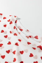 Sheer white t-shirt with red heart print and crew neck detail.