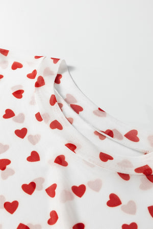 Sheer white t-shirt with red heart print and crew neck detail.