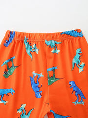 Orange toddler shorts with skateboarding dinosaurs pattern