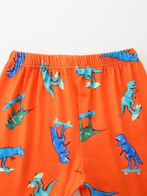 Orange toddler shorts with skateboarding dinosaurs pattern