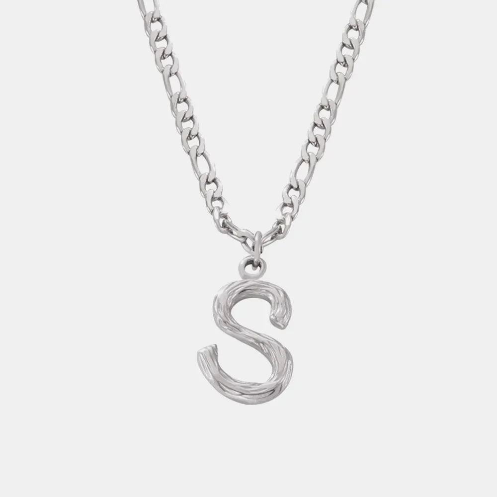Silver initial pendant necklace with textured letter S on a figaro chain