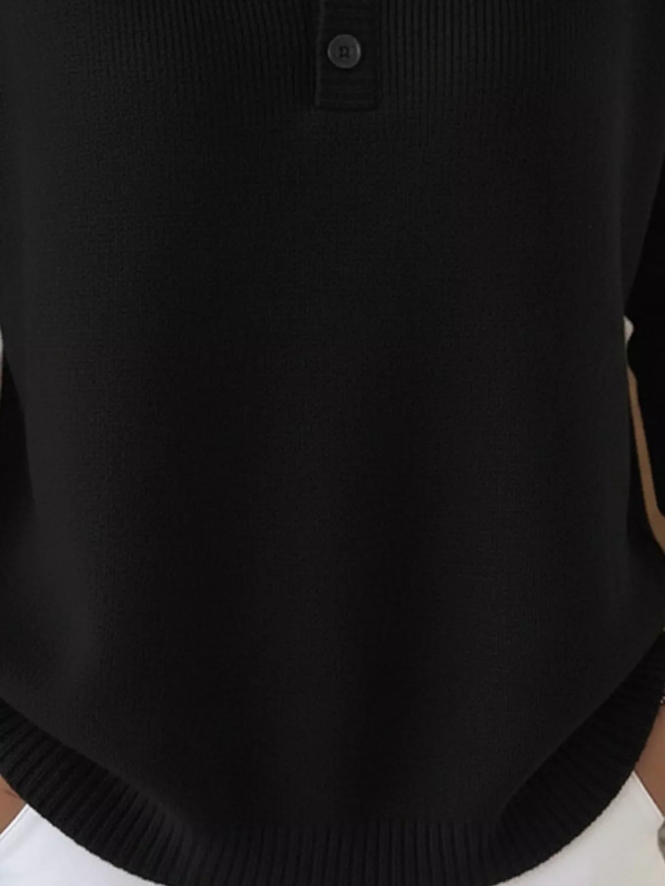 Black long-sleeve knit top with button detail at the neckline.