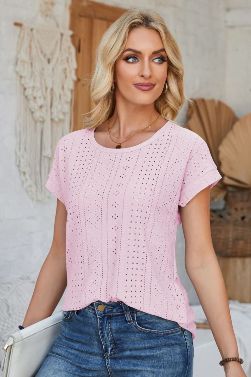 Blush pink perforated eyelet tee with cuffed short sleeves and a round neckline.