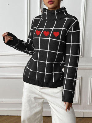 Black turtleneck sweater with white grid pattern and three red heart appliqués.
