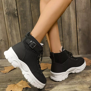 Black lace-up boots with plush accents and buckle detail on chunky white soles