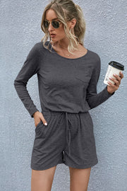Dark gray jersey pocket romper with drawstring waist and long sleeves.