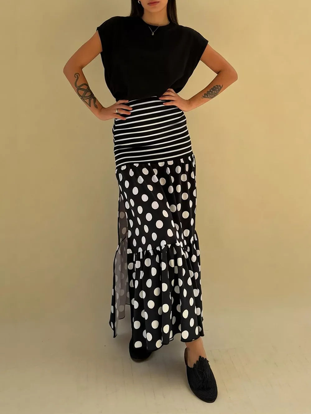 Black polka dot maxi skirt with high slit and tiered ruffle hem.