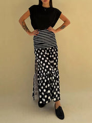 Black polka dot maxi skirt with high slit and tiered ruffle hem.