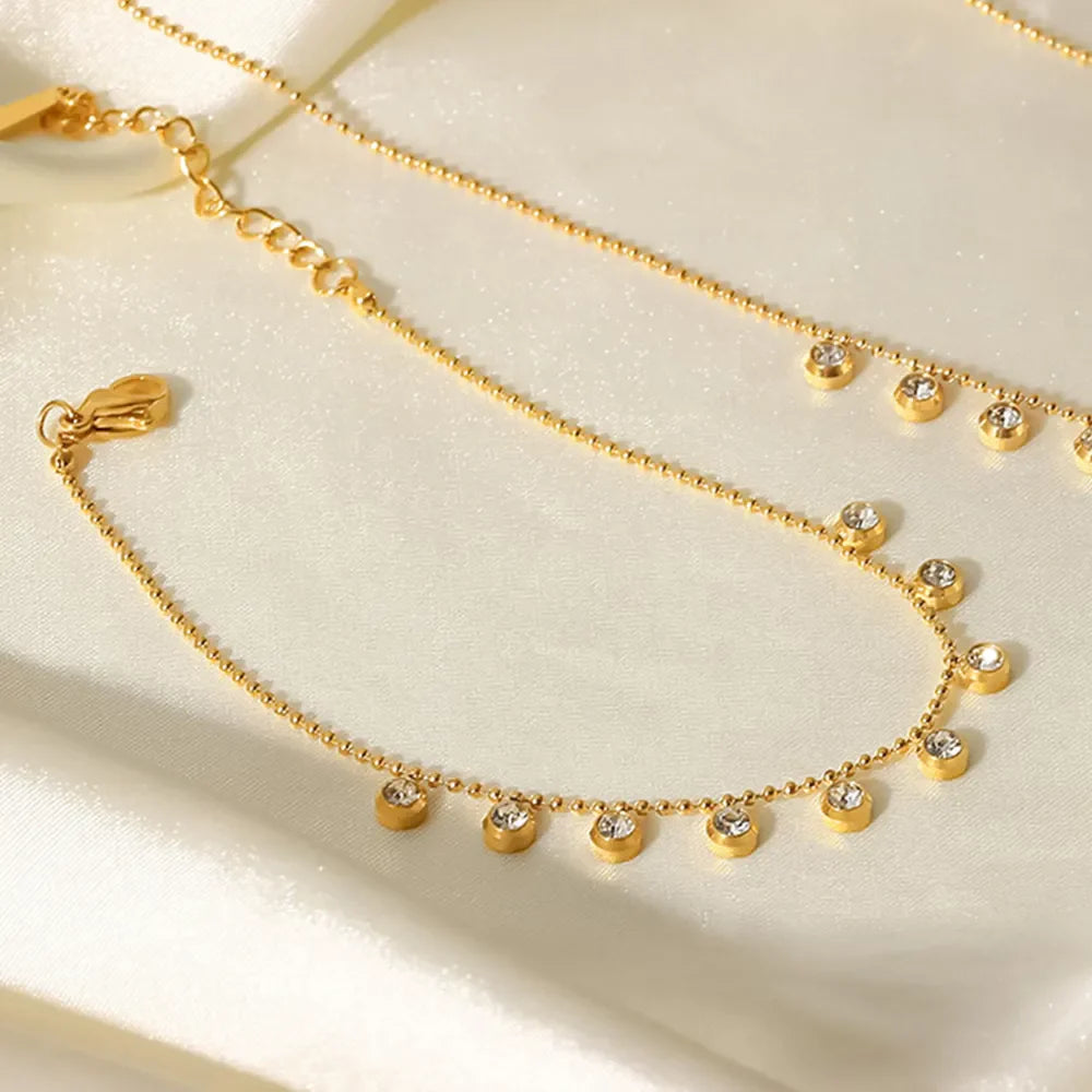 Gold bracelet with dangling zirconia beads and a beaded chain, 18K gold-plated.