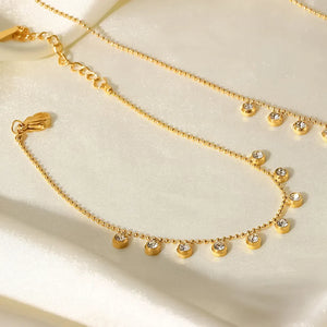 Gold bracelet with dangling zirconia beads and a beaded chain, 18K gold-plated.