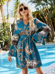 Deep teal baroque print wrap dress with leopard trim and bell sleeves.