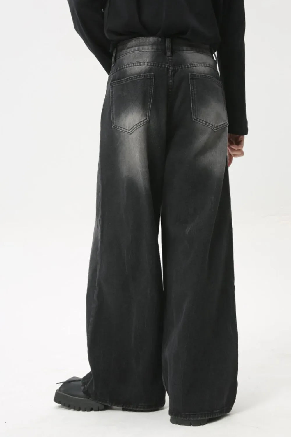 Whiskered wide leg denim jeans in dark wash, featuring a relaxed fit and distressed details.