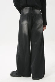 Whiskered wide leg denim jeans in dark wash, featuring a relaxed fit and distressed details.