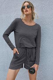Dark gray jersey pocket romper with long sleeves, drawstring waist, and shorts.