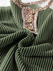 Dark green waffle knit henley top with leopard print placket and button details.