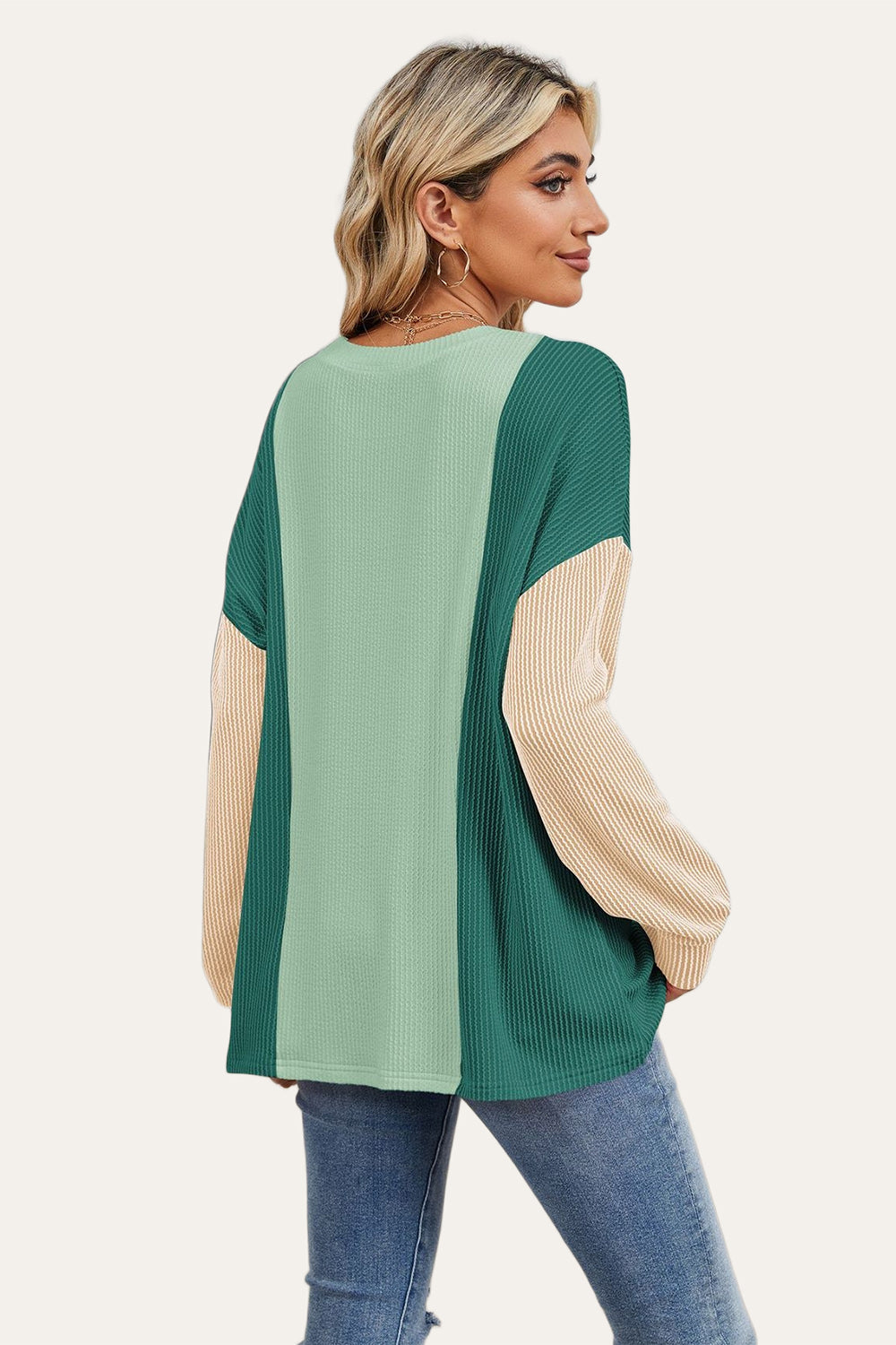 Colorblock waffle knit pullover with green and tan panels and long sleeves.