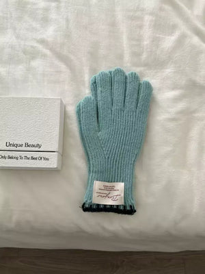 Blue ribbed knit gloves with black trim and a white tag.