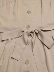Beige V-neck romper with tie waist and button details