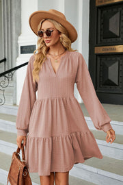 Textured babydoll mini dress in dusty pink with voluminous sleeves and tiered hem