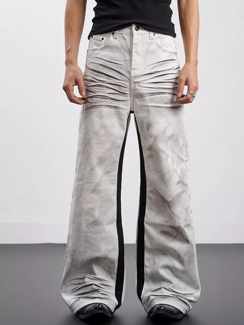 Men's wide-leg jeans in grey with black contrast stripes and ruched detailing.