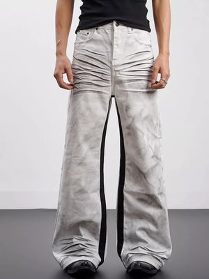 Men's wide-leg jeans in grey with black contrast stripes and ruched detailing.