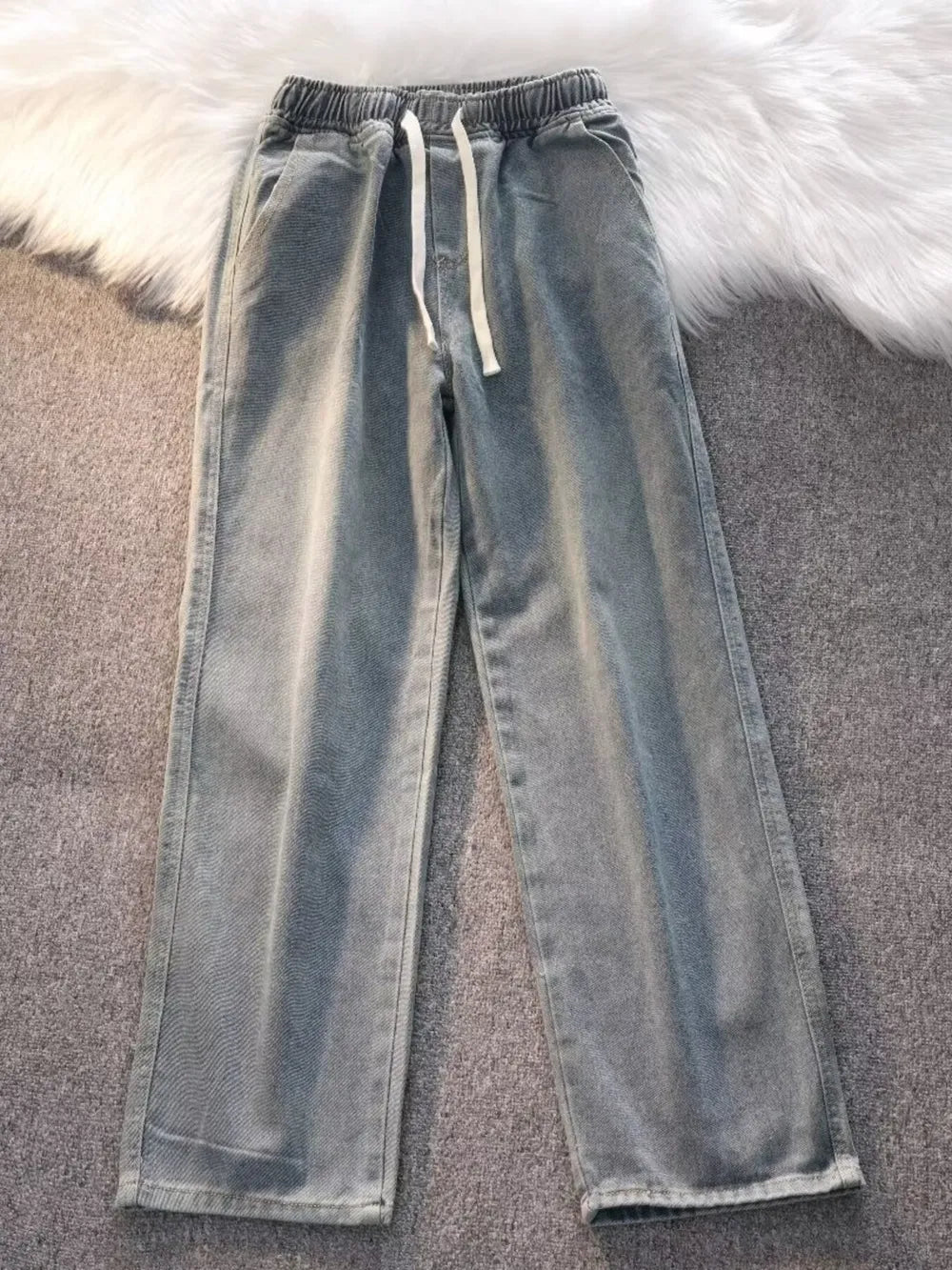 Blue vintage wash wide-leg jeans with drawstring waist and elastic waistband.
