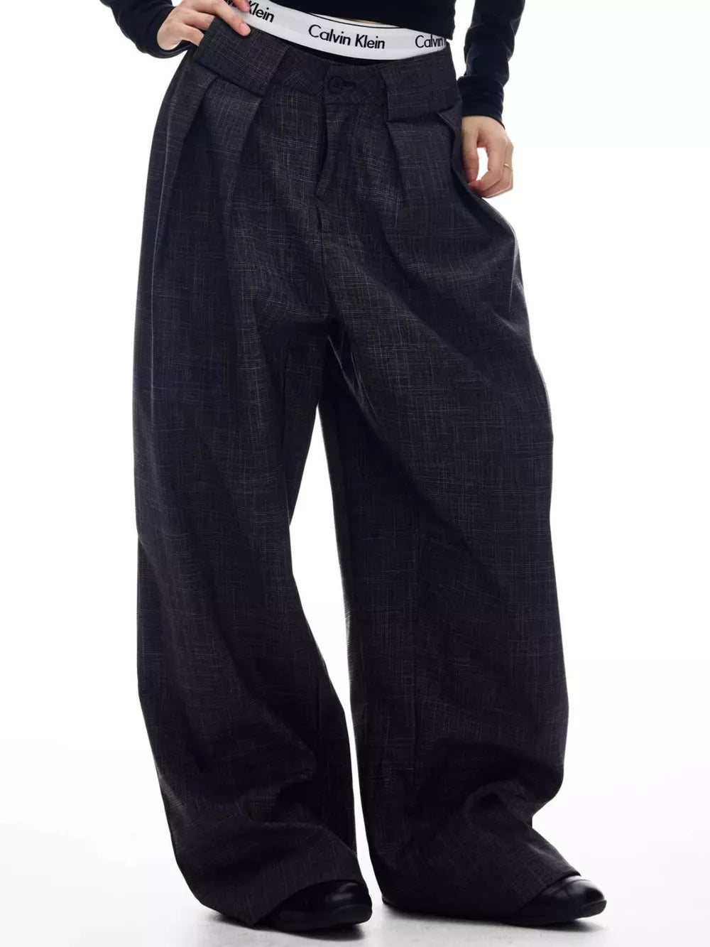 Men's dark grey wide-leg trousers with pleats and a textured fabric.