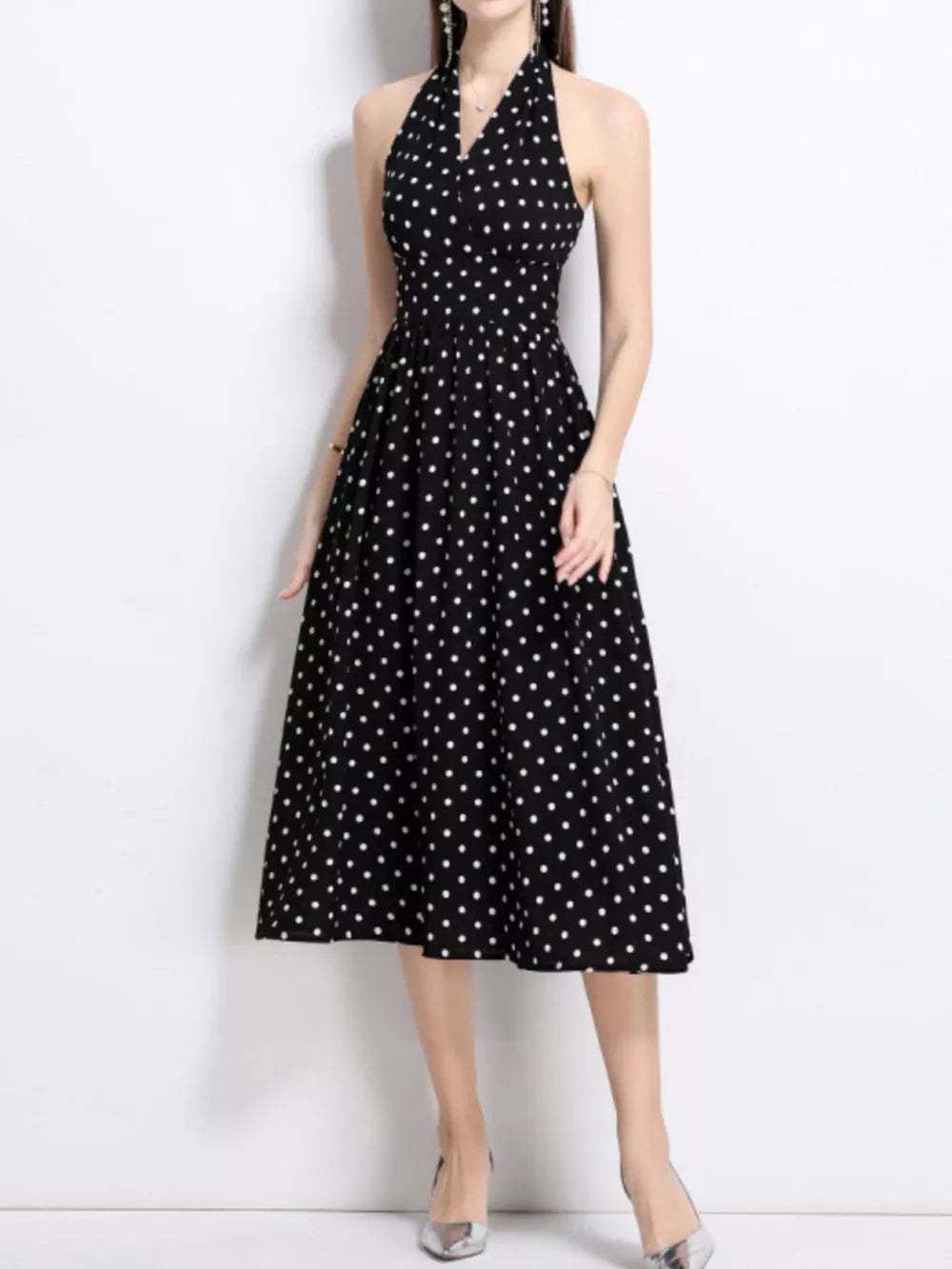 Black polka dot halter midi dress with a V-neck and flared skirt.
