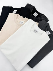 Acid wash oversized crew neck tees in black, beige, white, and gray.