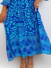 Vibrant abstract print midi dress in sky blue with button front and tiered hem.