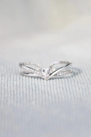 Silver V-shaped ring with diamond accents and a central heart-shaped diamond.
