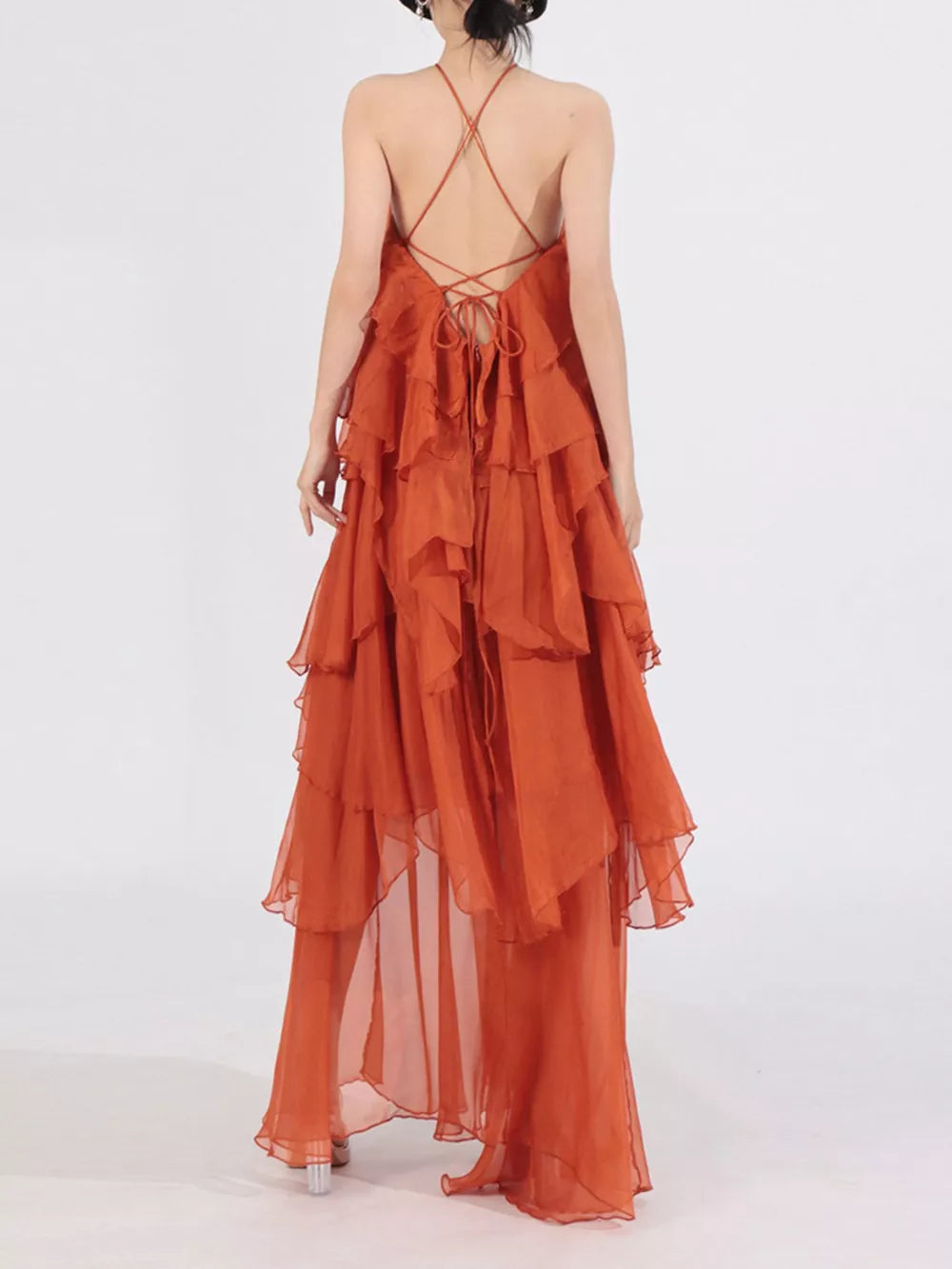 Orange halter maxi dress with cascading ruffles and crisscross back ties.