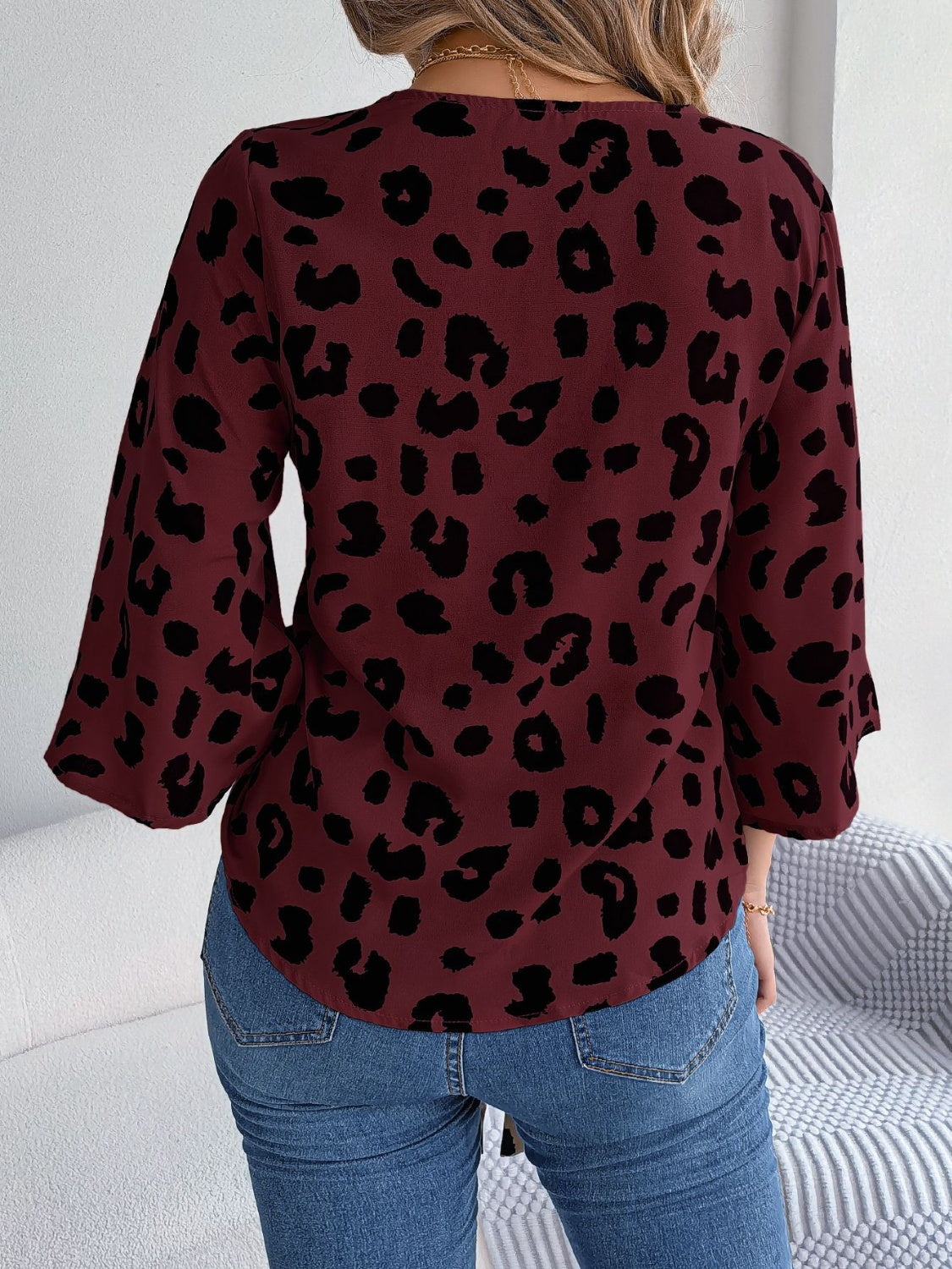 Burgundy leopard print tie-front blouse with bell sleeves.