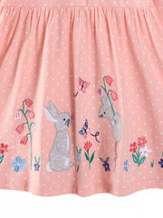 Watermelon pink polka dot cotton dress with embroidered bunnies, butterflies, and flowers.