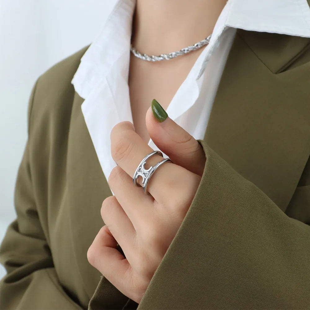 Silver double banded open ring with cut-out detail on a woman's hand.