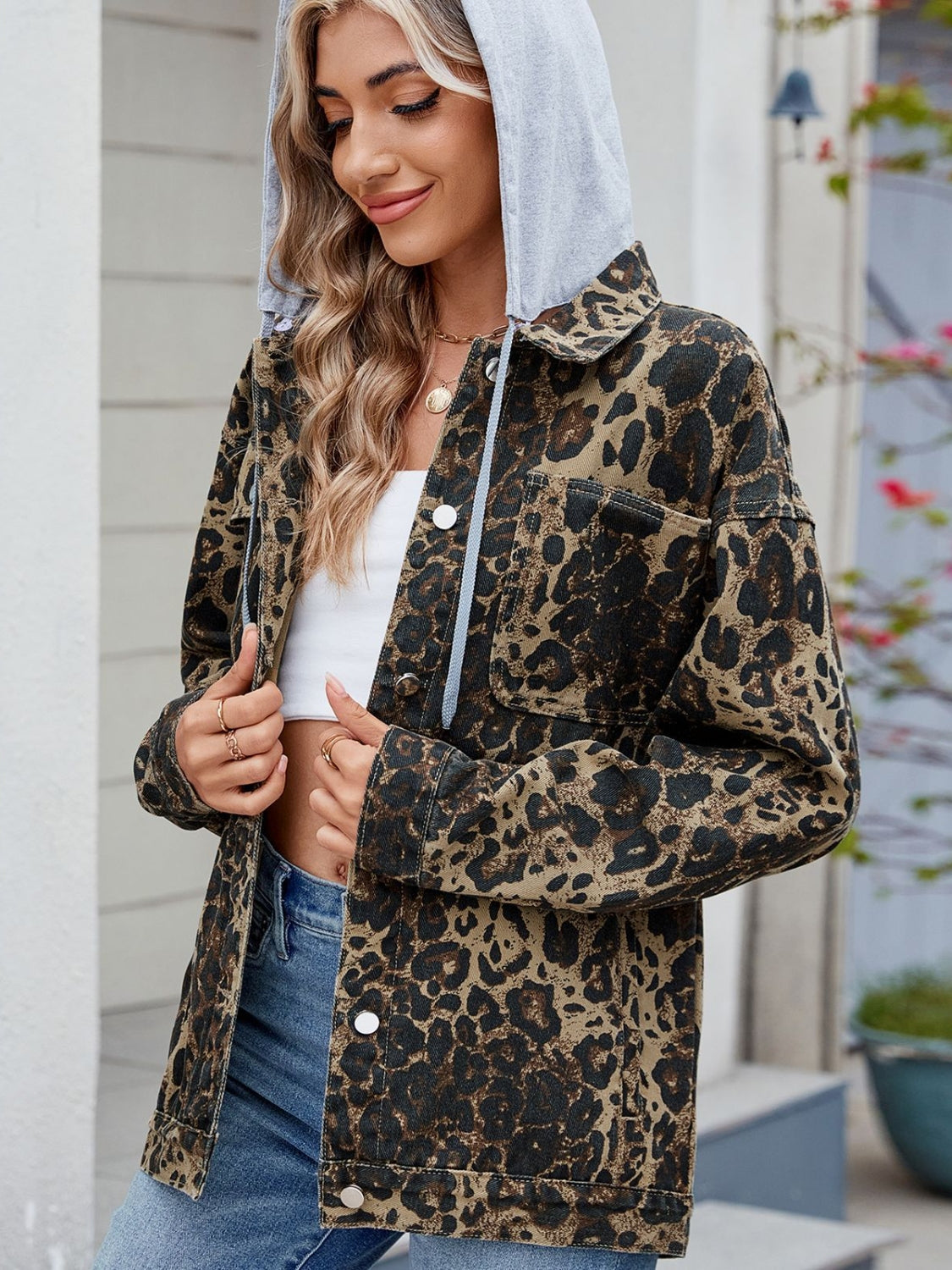 Leopard print denim shacket with removable grey hood and button front.