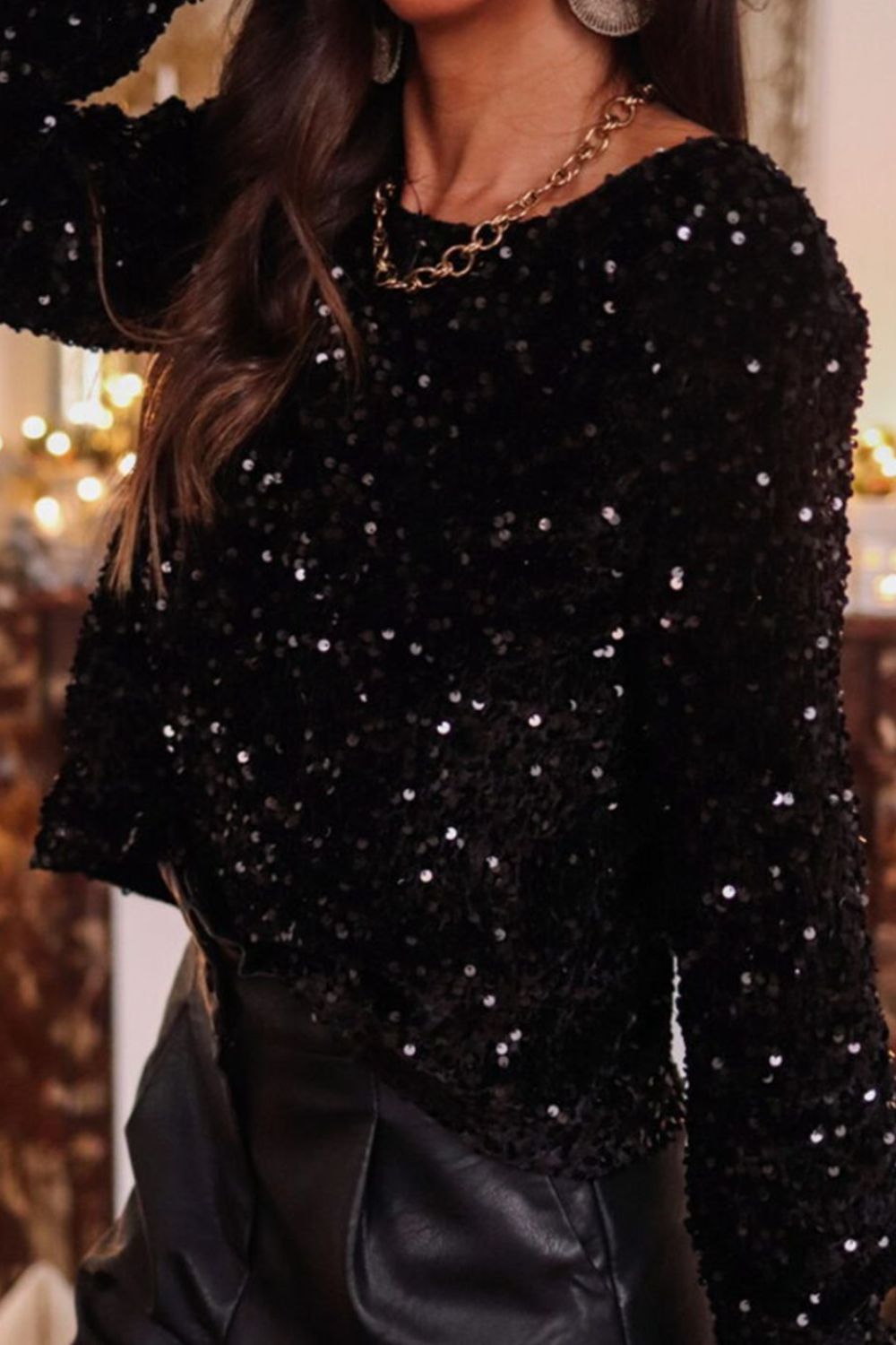 Black sequin backless blouse with long sleeves and a crew neck.