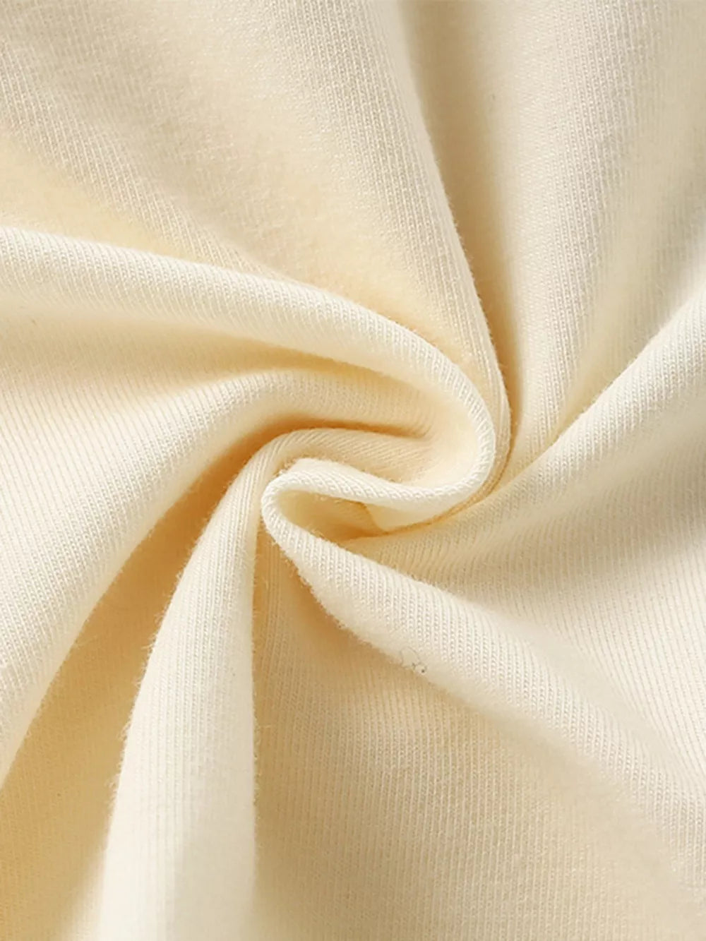 Cream cotton fabric detail of a toddler dress