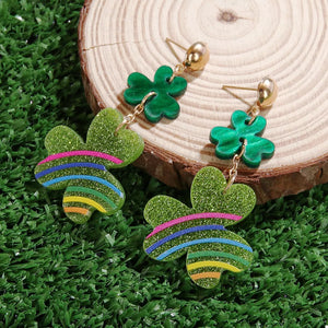 Gold dangle earrings with green glitter clover charms and colorful stripes