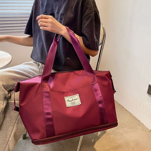 Large capacity duffel bag in deep purple with dual handles and a front patch.