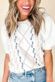 White cable knit sweater with puff sleeves and diamond pattern detail.