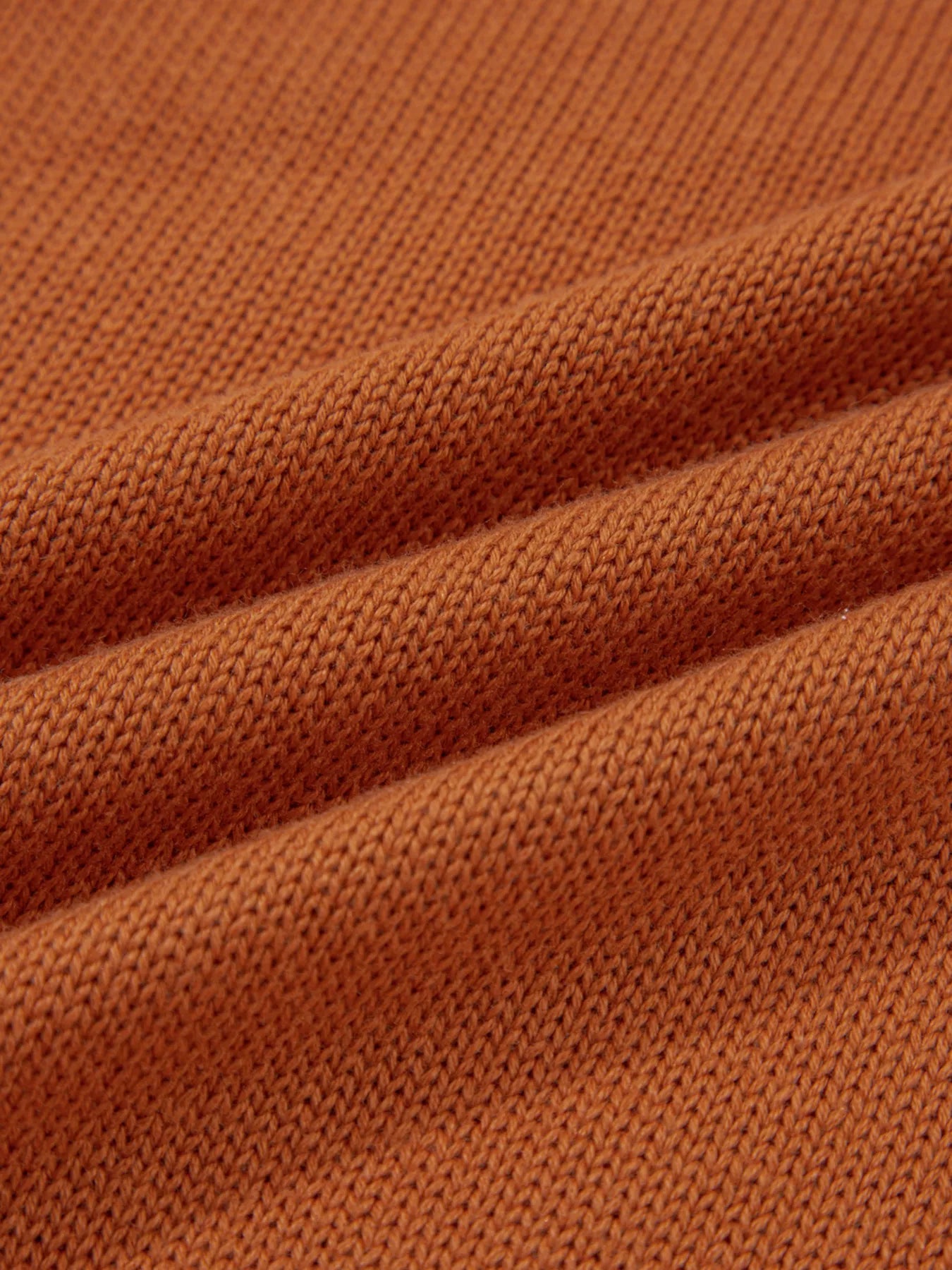 Caramel acrylic blend sweater with a textured knit and draped fabric detail.