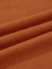 Caramel acrylic blend sweater with a textured knit and draped fabric detail.
