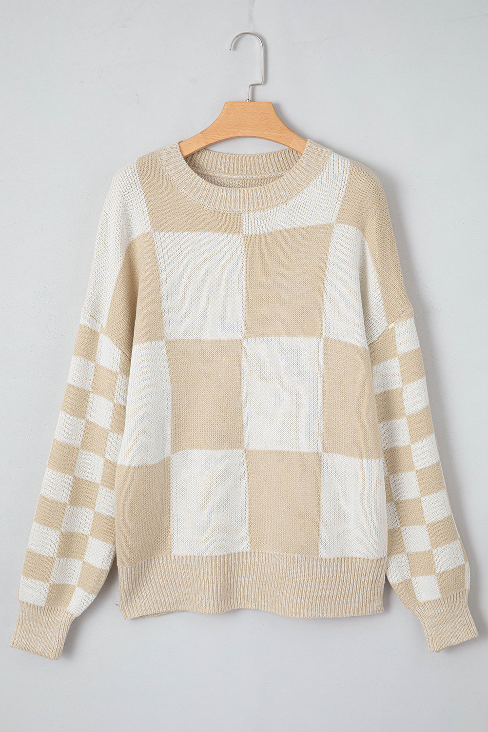 Beige and white checkerboard knit sweater with crewneck and ribbed cuffs and hem.